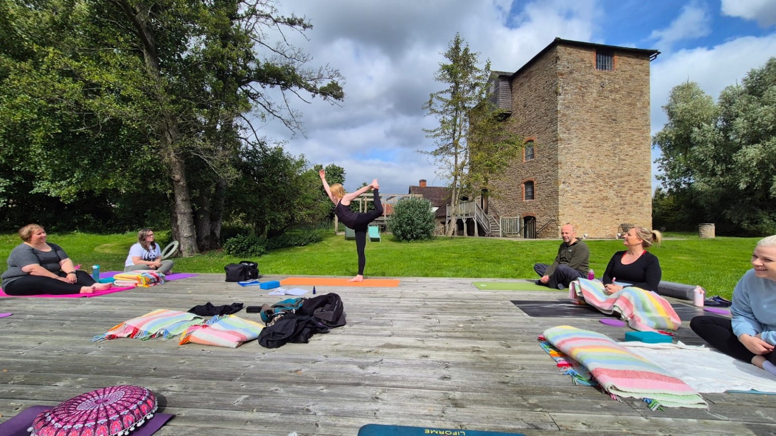 Gem demonstrating a yoga pose during an outdoor day retreat